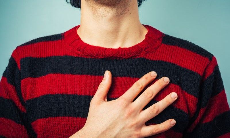 Young ethnic man is pledging allegience with his right hand raised