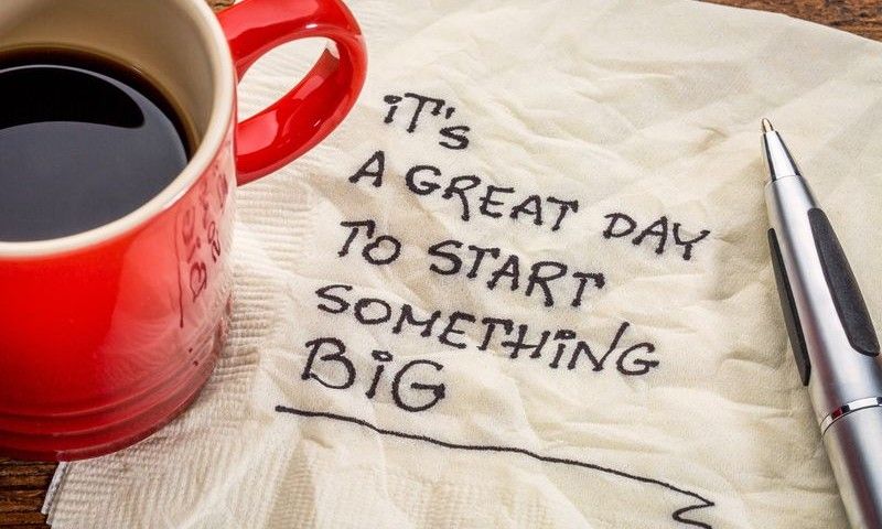It is a great day to start something big - motivational handwriting on a napkin with a cup of coffee