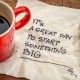 It is a great day to start something big - motivational handwriting on a napkin with a cup of coffee