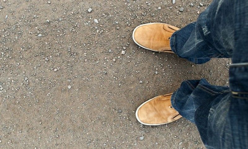 yellow boots on the road, a man standing on the road
