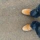 yellow boots on the road, a man standing on the road