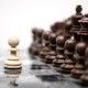 One pawn staying against full set of chess pieces.