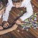Happy boy and girl collect puzzle lying on the floor closeup