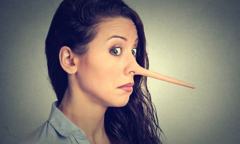 Woman with long nose isolated on grey wall background. Liar concept. Human face expressions, emotions, feelings