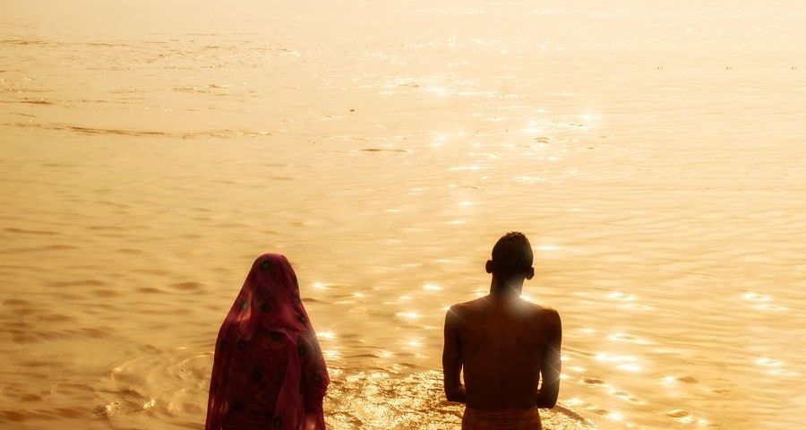 VARANASI, INDIA - AUGUST 27, 2008: unidentified people make the morning rituals (puja) in the water of the river Ganges