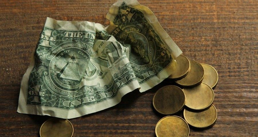 money and paper on a brown wooden background.The concept of poverty