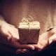 Giving a gift, handmade present wrapped in paper. Christmas time, vintage mood.