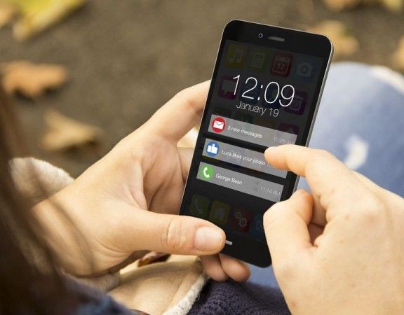 connectivity concept: woman holding a 3d generated smartphone with notifications on the screen. Graphics on screen are made up.