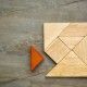 a missing piece in a square built from tangram pieces, a traditional Chinese puzzle game, slate rock background