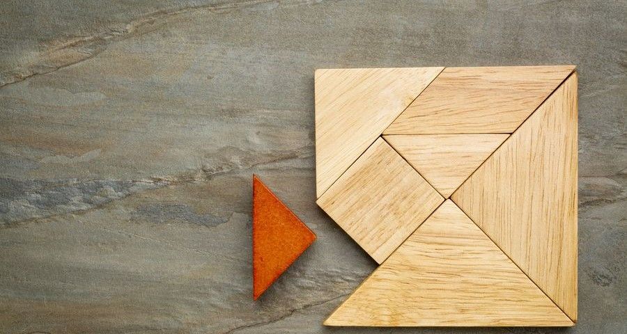 a missing piece in a square built from tangram pieces, a traditional Chinese puzzle game, slate rock background