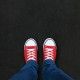 Feet wearing red shoes on black background with space for text