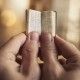 Two hands holding a very small Bible.