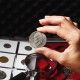 Woman looking at the collector's Dollar coin, soft focus background